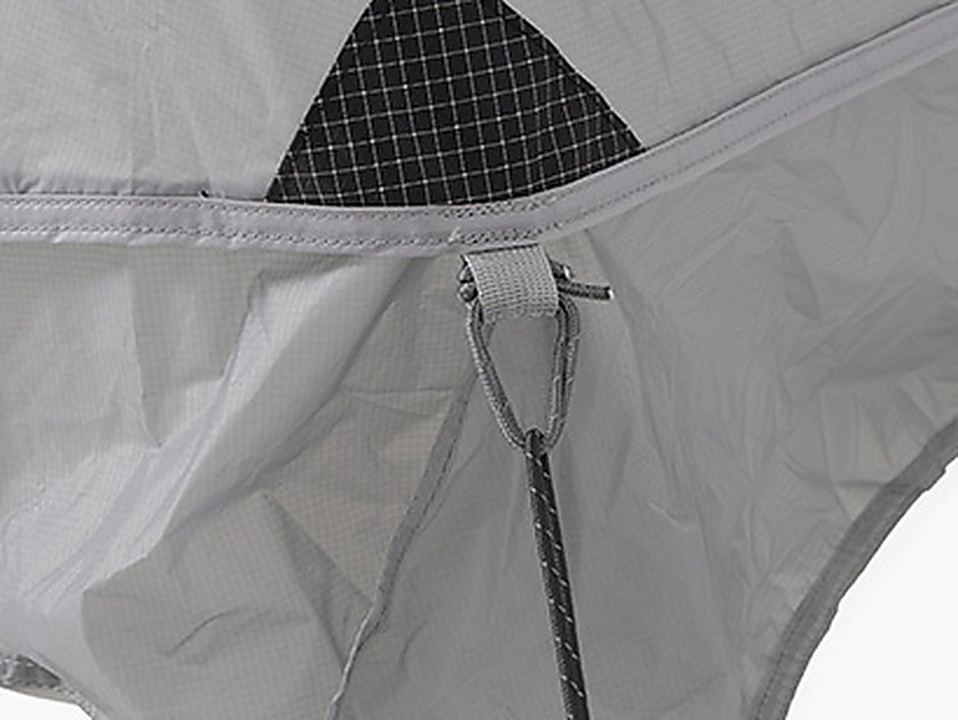 Close-up of a webbing anchor loop on the rainfly with a pre-attached reflective guyline and mesh corner vent.