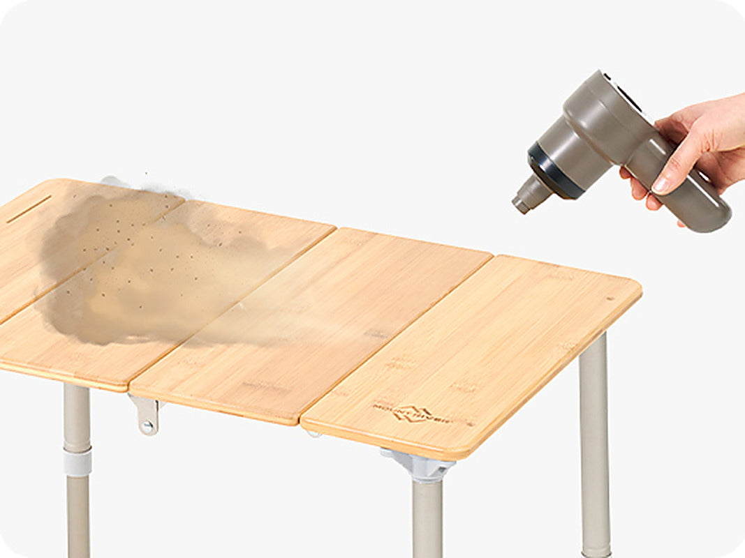 Tornado 25 air pump blowing dust and debris off a folding bamboo camp table (table sold separately).