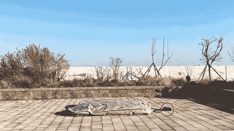 Time-lapse: an air tent inflates on a wooden deck, the pump running at the inlet valve.