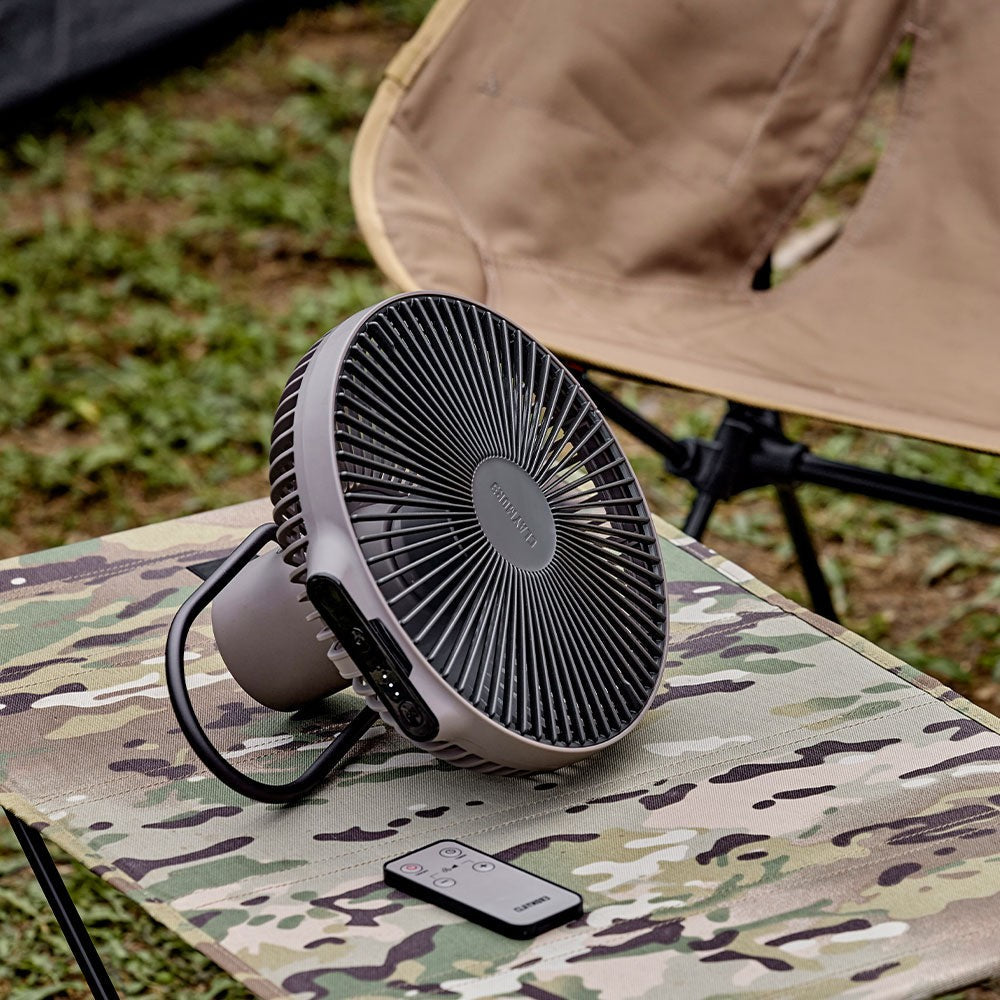V1040 fan in Warm Grey with its remote on a camp cot, running on battery power