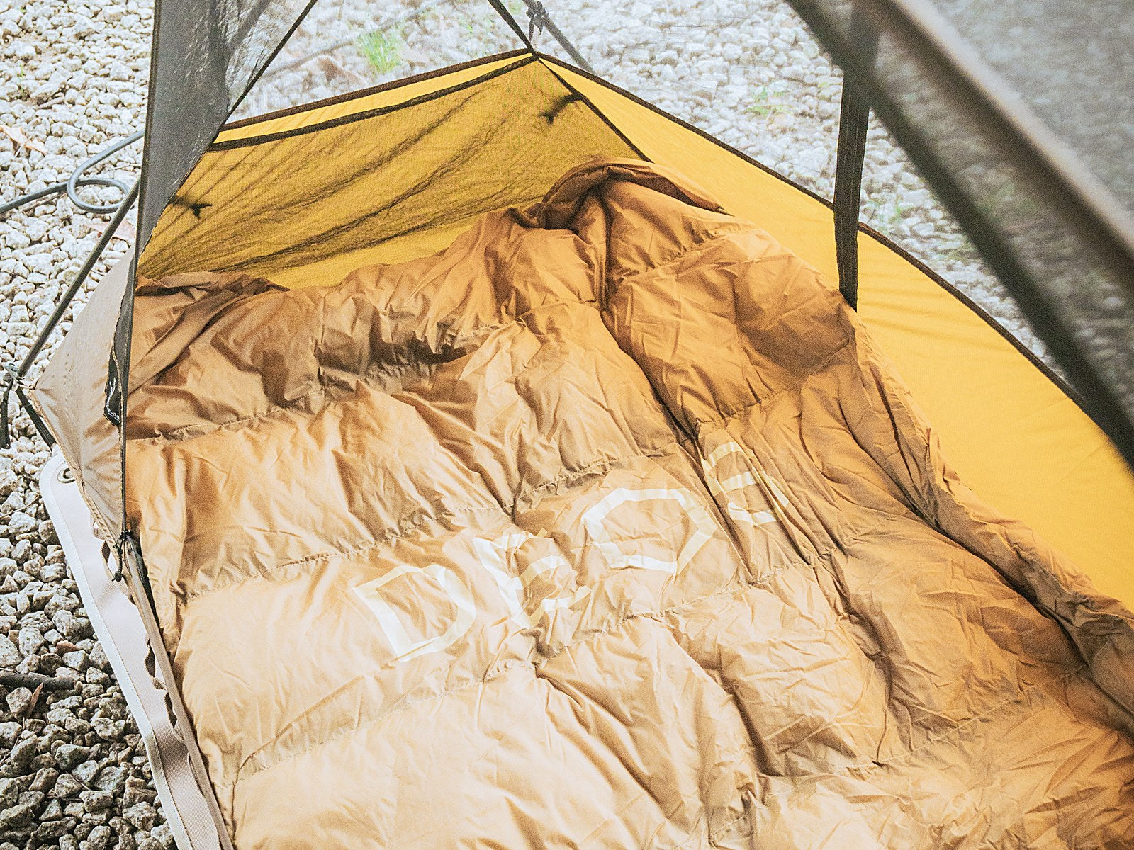 Tan DEOS camp comforter lining detail on a camp cot