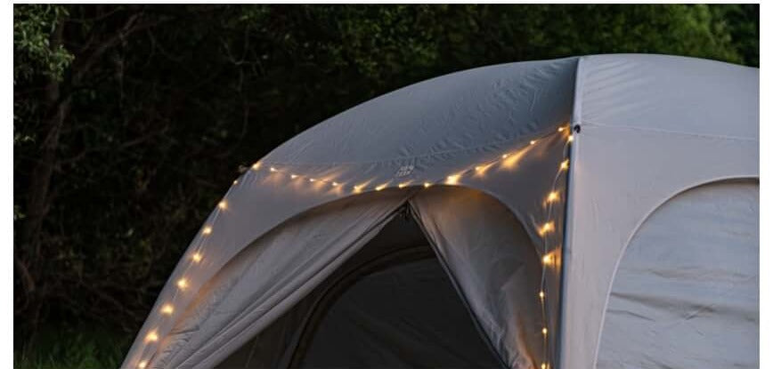 String light wrapped around a tent's seams, glowing warm in the dark