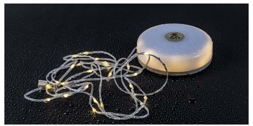 Lantern and string light on a wet surface with water droplets