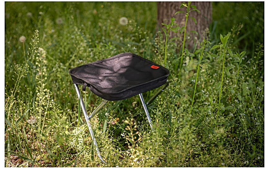 Folding BBQ stool set up outdoors on the grass