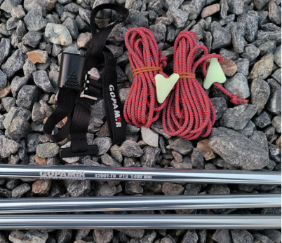 Gopamir G450 spare-pole kit with red reflective guy lines and aluminum pegs laid on gravel ground