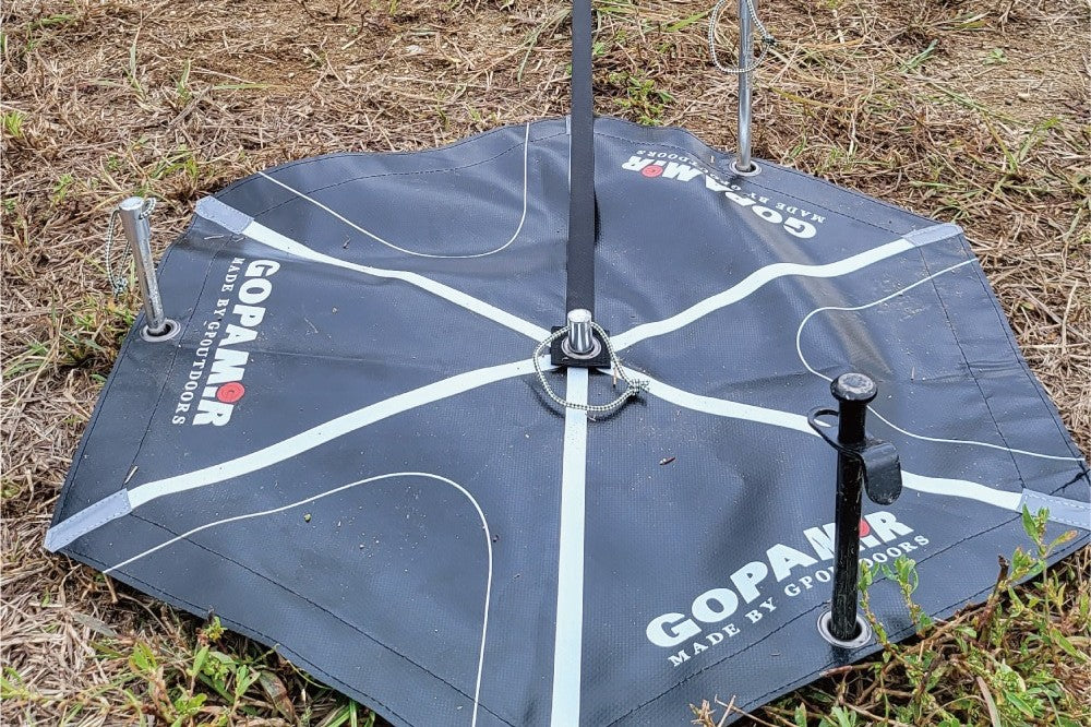 Center guide board placed flat on ground with six webbing straps radiating to hexagonal corners