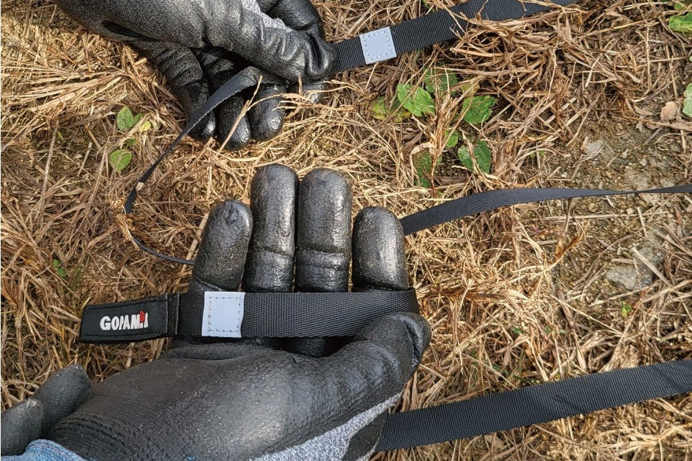 Hand holding the Gopamir T720+ guy-line webbing strap, close-up