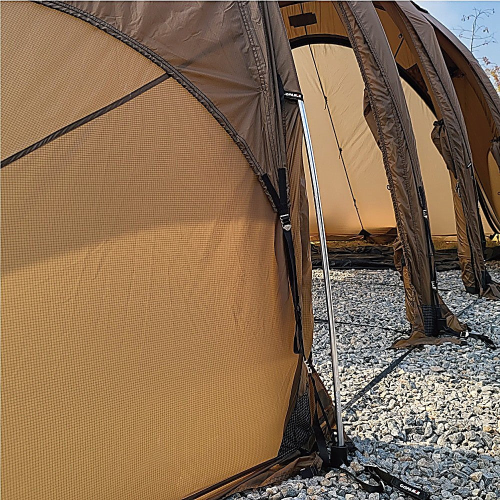 T720+ spare pole supporting a brown tent door panel, upright aluminum shaft with black foot on gravel