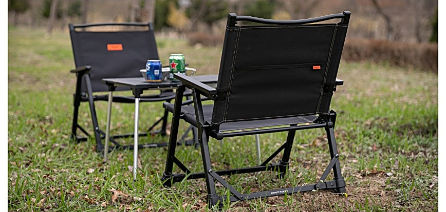 Two Impact Fusion Chairs set up on grass beside a camp table