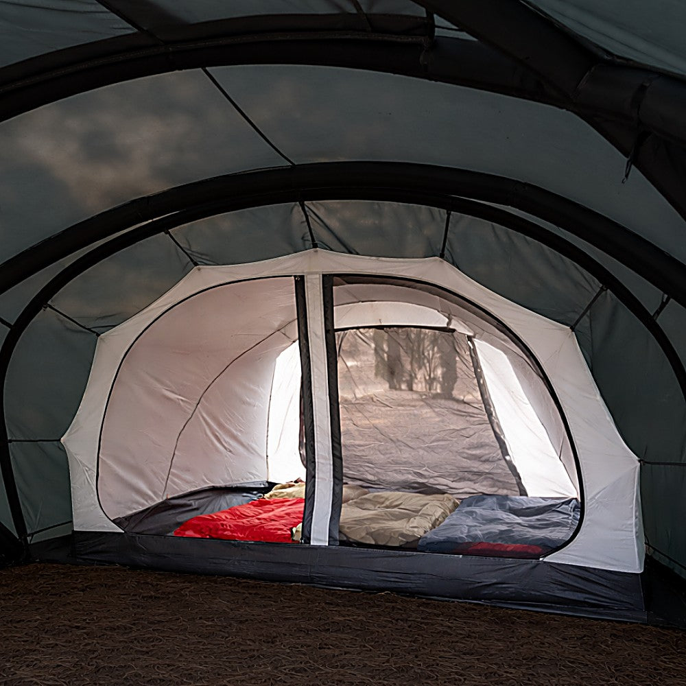 Inner tent installed inside the Shelter GM, showing an enclosed sleeping room with sleeping bags lit from inside at dusk