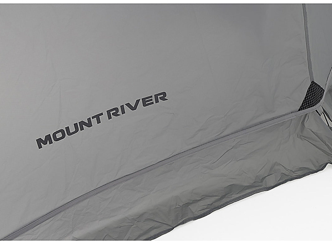 Close-up of the grey 20D ripstop nylon rainfly panel with the printed Mount River wordmark and bound hem seam.