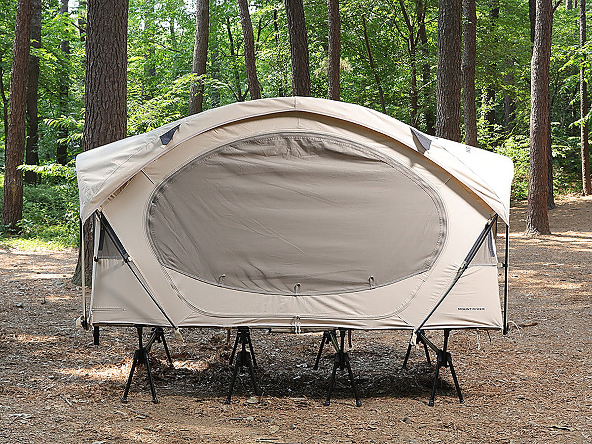 Neo Nest 80 Cot Tent (Natural), pitched on a camp cot in a pine forest