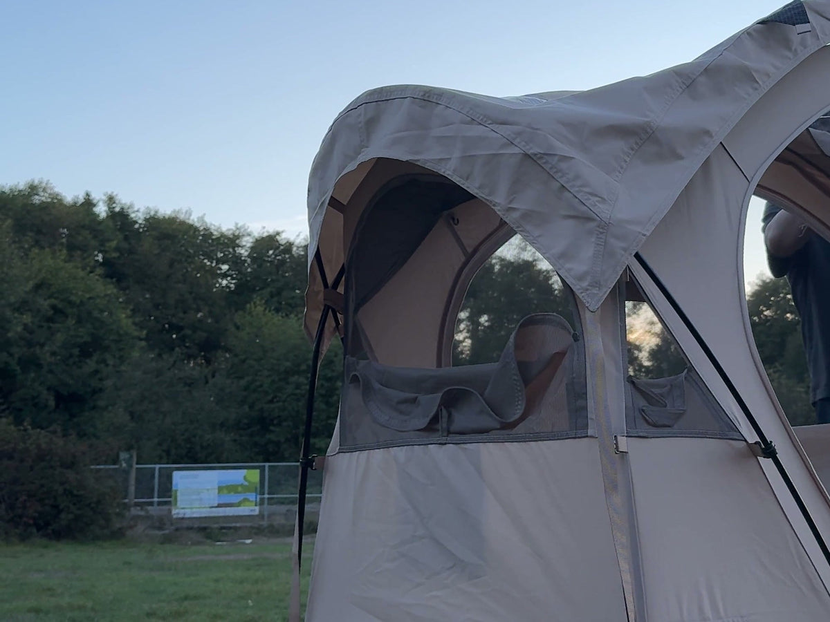 Neo Nest 80 at dusk with the included roof cover fitted, its clear skylight panel visible from outside (cot sold separately).