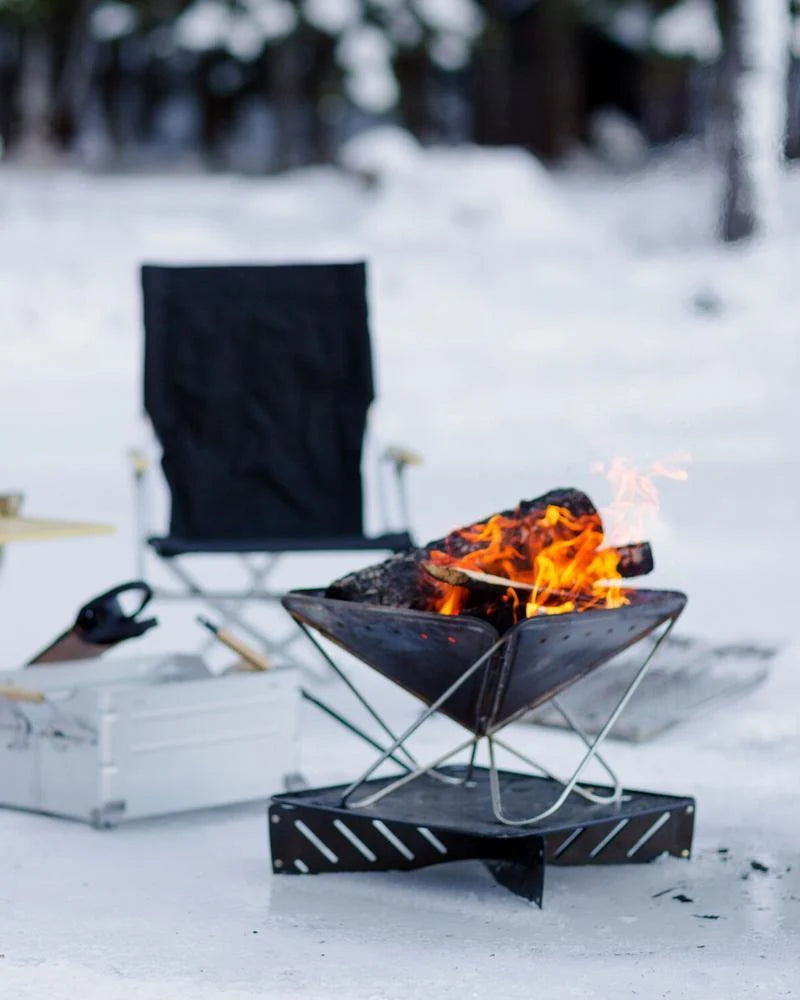 Pack & Carry Fireplace with a fire burning at a snowy campsite