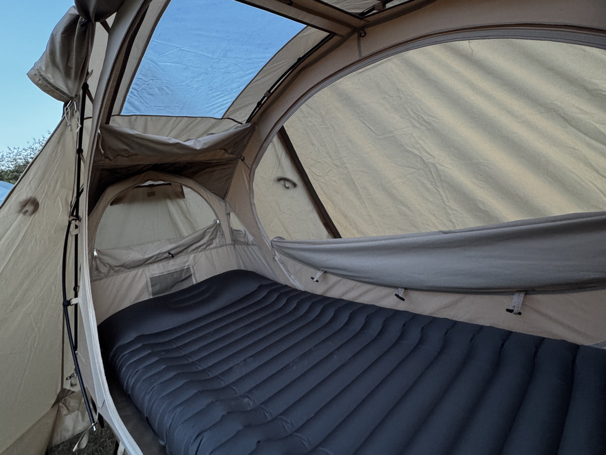 Sky Mat Wave 77 in Dark Gray on a cot inside a cot tent, wave cells across the surface (cot and tent sold separately).