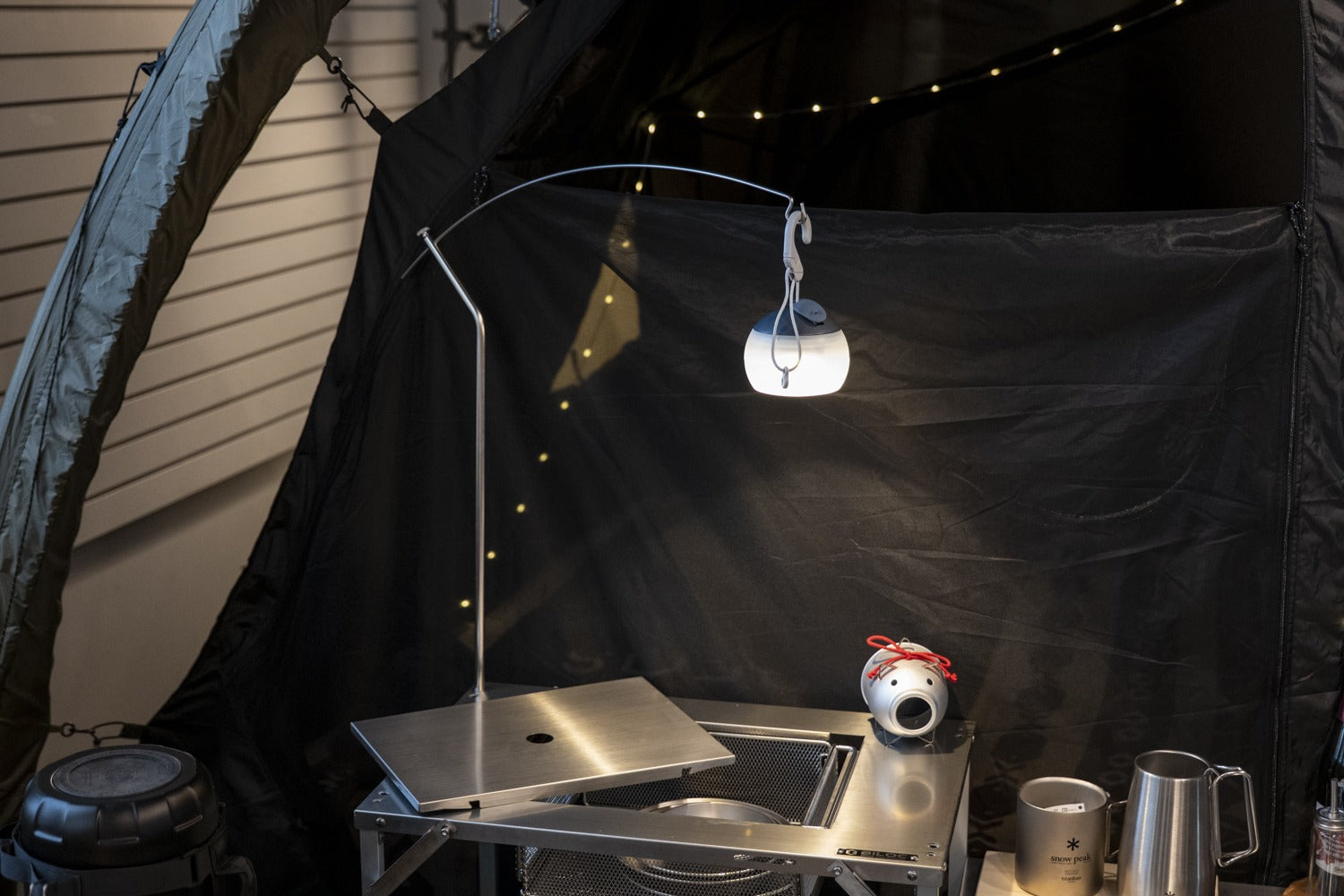 Stella shelf under a hanging lantern at night, top plate slid open. The lantern and props shown are not included.