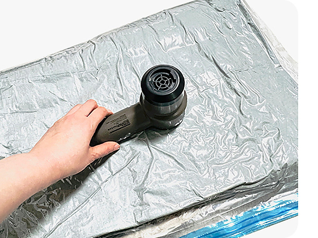 Tornado 25 air pump drawing air out of a vacuum storage bag full of clothing (bag sold separately).