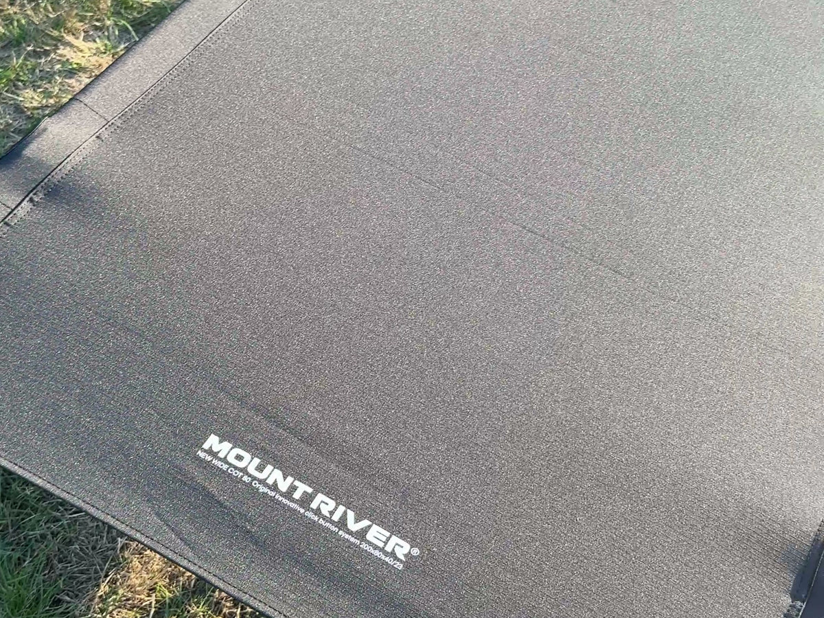 Close-up of the Wide Cot 80 deck fabric and its printed Mount River logo.